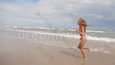 一个快乐的小女孩正在享受大海。 浪来岸边，<strong>欢度</strong>小儿女..